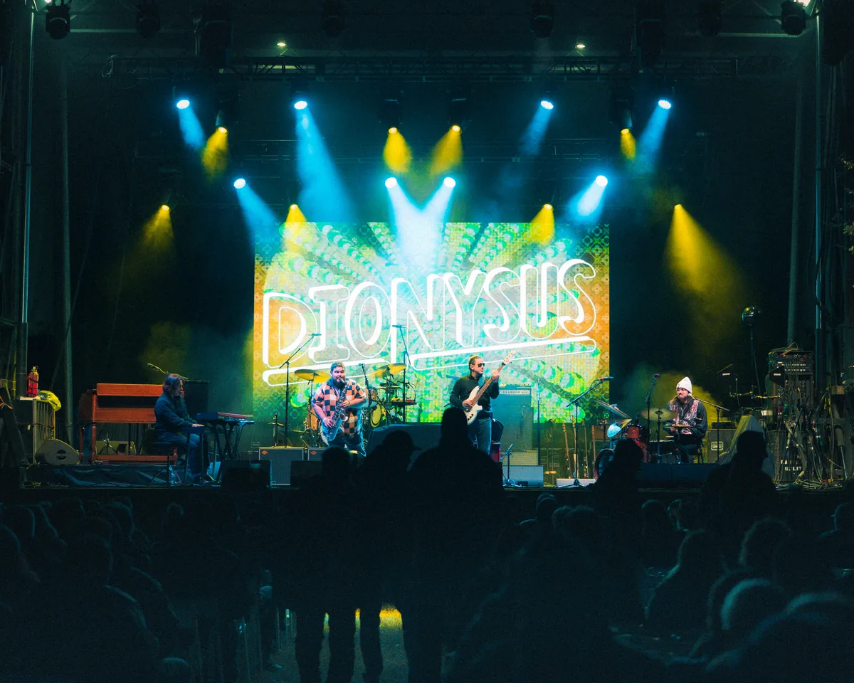 Dionysus band performing on illuminated stage with colorful lighting in St. Augustine, Florida
