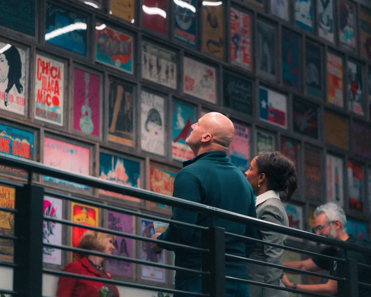 Two people viewing colorful poster wall display at cultural venue in St. Augustine, Florida
