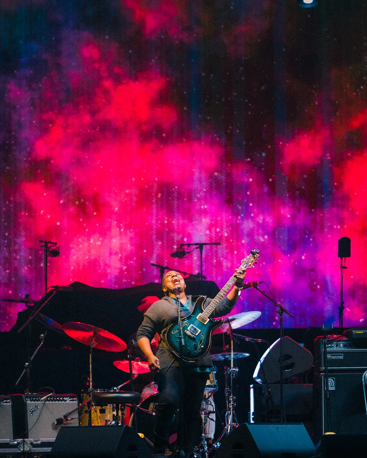 Musician performing with electric guitar against vibrant nebula backdrop in St. Augustine, Florida