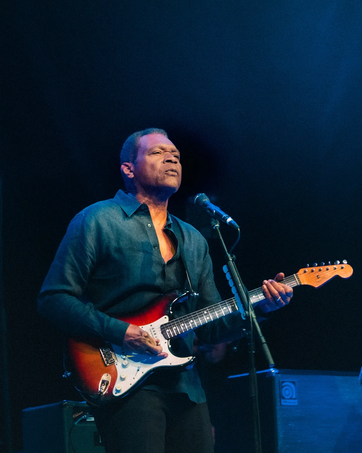 Robert Cray performing with electric guitar and microphone on stage in St. Augustine, Florida